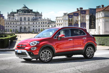 Red Fiat 500X SUV parked before an ornate European palace, 4K Ultra HD PC desktop wallpaper/background showcasing the Fiat car and vehicle in an urban plaza.