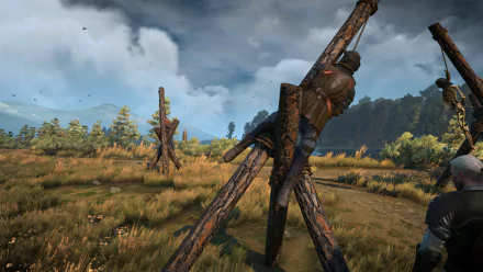 HD PC desktop wallpaper/background from the video game The Witcher 3: Wild Hunt — a stormy meadow with wooden tripods holding a hanging body, scattered trees and distant hills.
