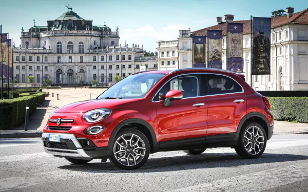 Red Fiat 500X SUV parked before an ornate European palace, 4K Ultra HD PC desktop wallpaper/background showcasing the Fiat car and vehicle in an urban plaza.