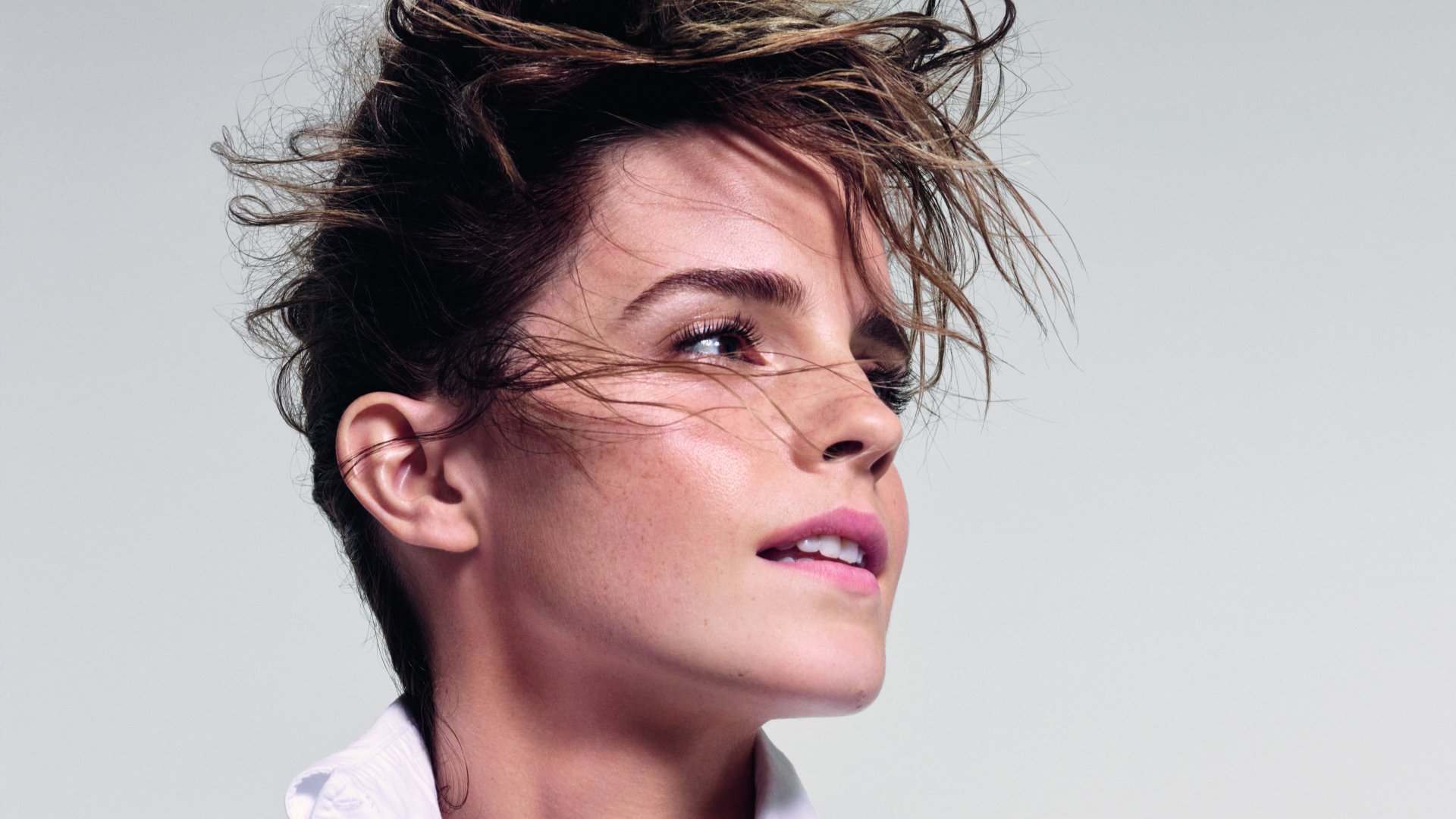 Close-up portrait of celebrity Emma Watson with windswept hair, captured in stunning 4K Ultra HD quality for a vibrant PC desktop wallpaper background.