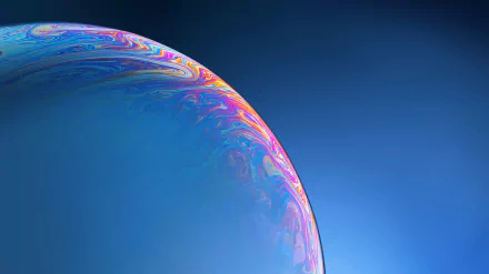 HD PC desktop wallpaper featuring an abstract close-up of a bubble with vibrant, swirling colors against a smooth blue background.