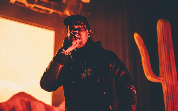 HD desktop wallpaper featuring a performance by a hip-hop artist, with warm stage lighting and a vibrant desert backdrop.