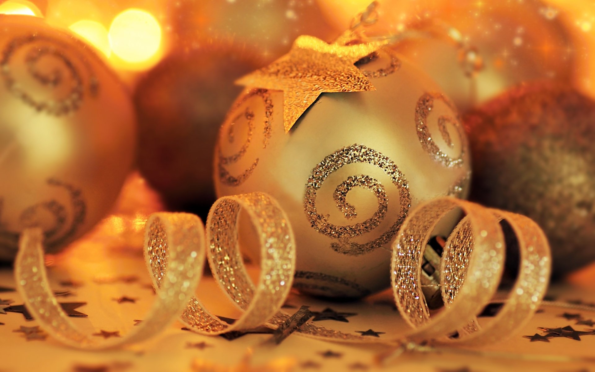 HD desktop wallpaper of golden Christmas ornaments featuring sparkling swirls and ribbons, radiating warmth and holiday spirit.