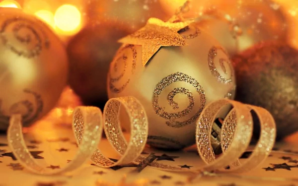 HD desktop wallpaper of golden Christmas ornaments featuring sparkling swirls and ribbons, radiating warmth and holiday spirit.