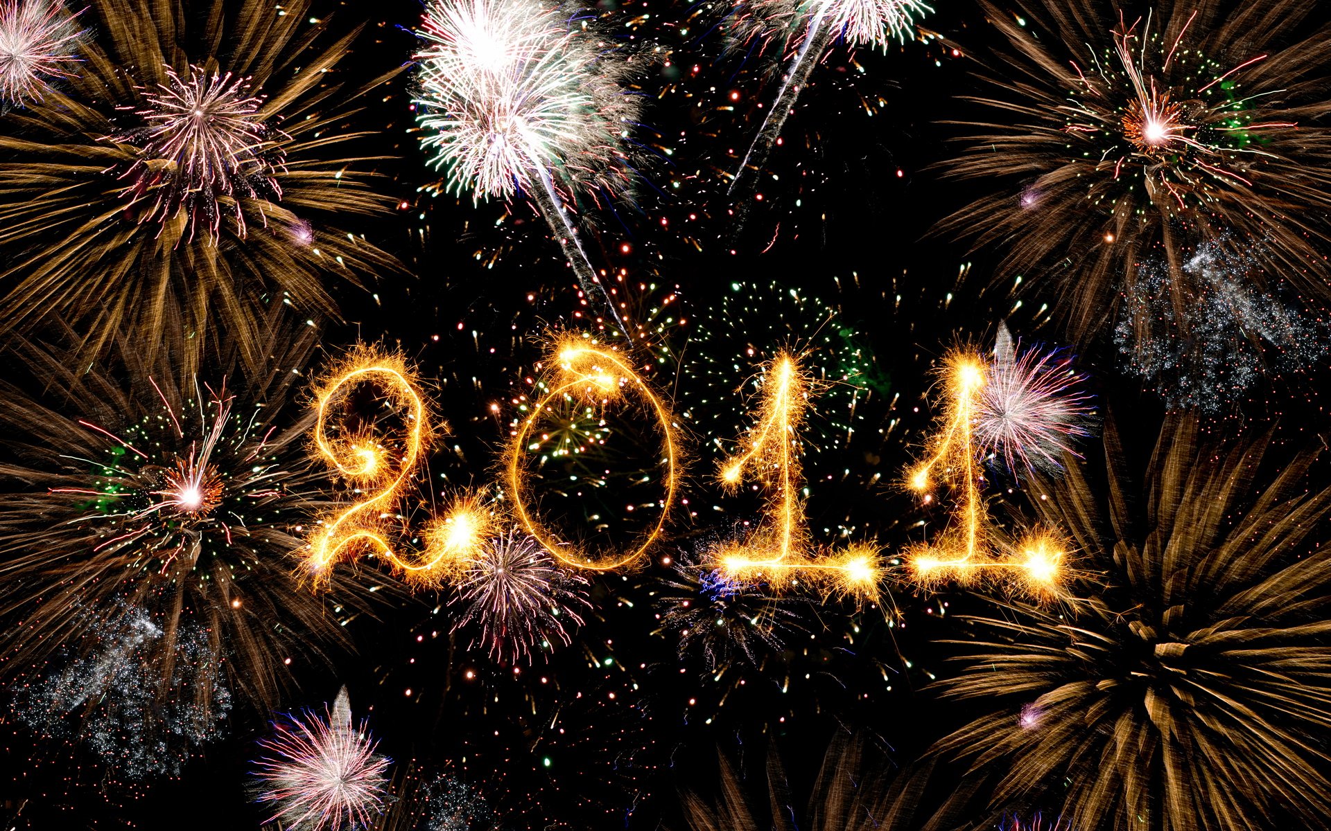 HD desktop wallpaper for New Year 2011 featuring vibrant fireworks illuminating the night sky, with 2011 written in sparkling lights at the center.