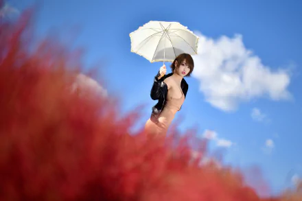 HD PC desktop wallpaper of a woman model holding a white umbrella against a vivid blue sky, with soft red floral blur in the foreground.