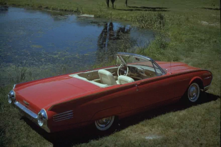 HD PC desktop wallpaper featuring a classic red Ford Thunderbird convertible parked on grass near a reflective pond.