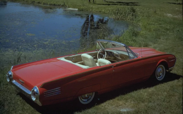 HD PC desktop wallpaper featuring a classic red Ford Thunderbird convertible parked on grass near a reflective pond.