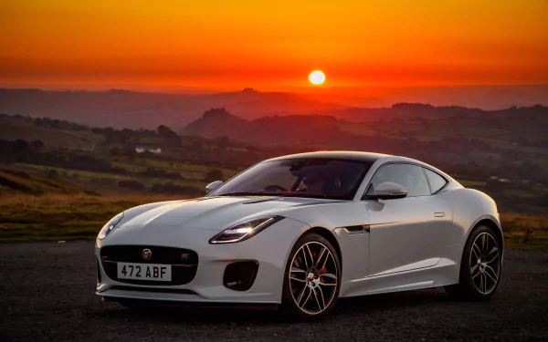 White Jaguar F-Type supercar parked on a coastal road at sunset, captured as a 4K Ultra HD PC desktop wallpaper background.