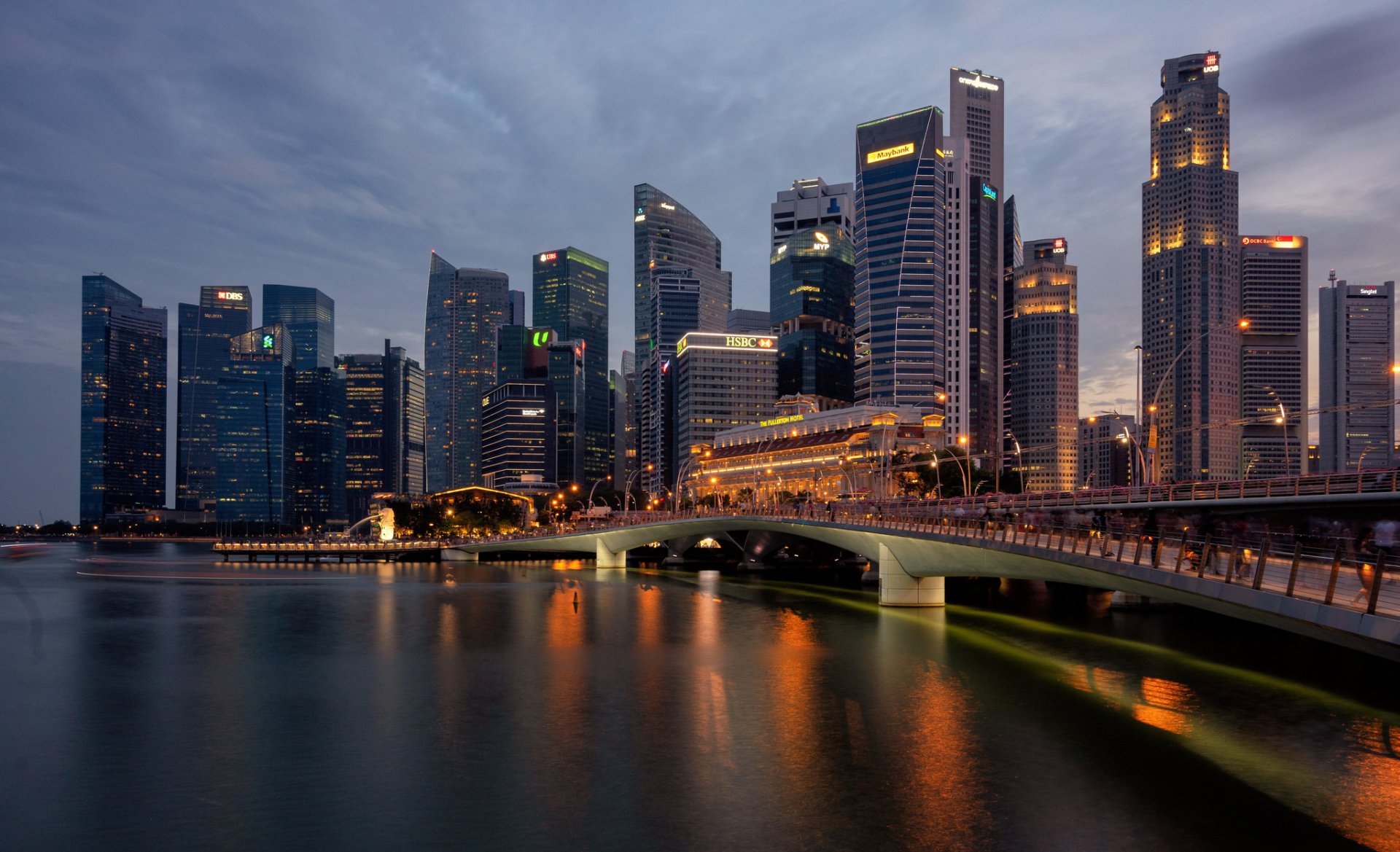 HD desktop wallpaper showcasing Singapore's city skyline at dusk with the illuminated Esplanade Bridge spanning calm waters.