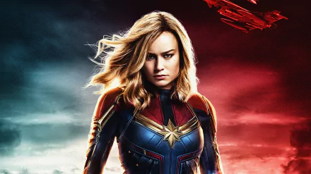 HD desktop wallpaper featuring Brie Larson as Carol Danvers, aka Captain Marvel, in her superhero suit from the Avengers movie, with a dramatic sky and aircrafts in the background.