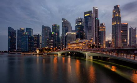 HD desktop wallpaper showcasing Singapore's city skyline at dusk with the illuminated Esplanade Bridge spanning calm waters.