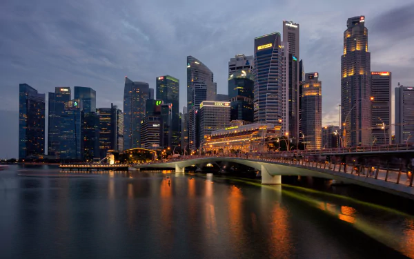 HD desktop wallpaper showcasing Singapore's city skyline at dusk with the illuminated Esplanade Bridge spanning calm waters.