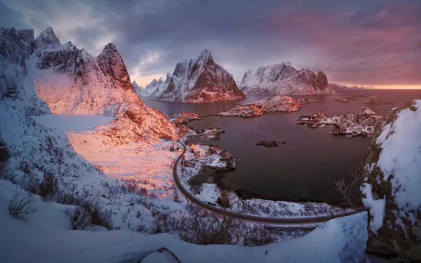 Photography of snow-covered Lofoten mountains and fjord at sunrise, a winding bridge and coastal village — HD PC desktop wallpaper and background.