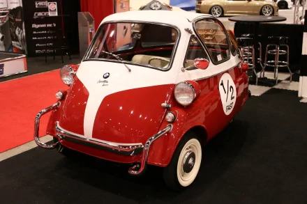 HD desktop wallpaper featuring a classic red and white BMW Isetta microcar displayed at an indoor auto show.