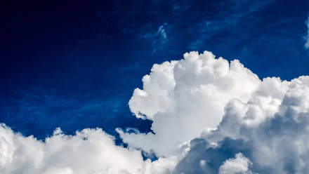 HD wallpaper featuring a vibrant blue sky with fluffy white clouds.