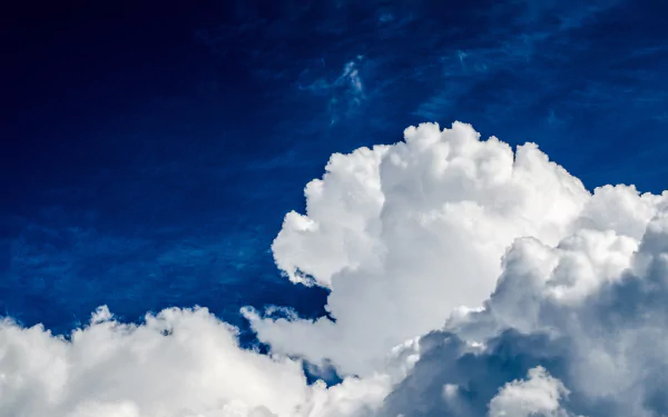 HD wallpaper featuring a vibrant blue sky with fluffy white clouds.