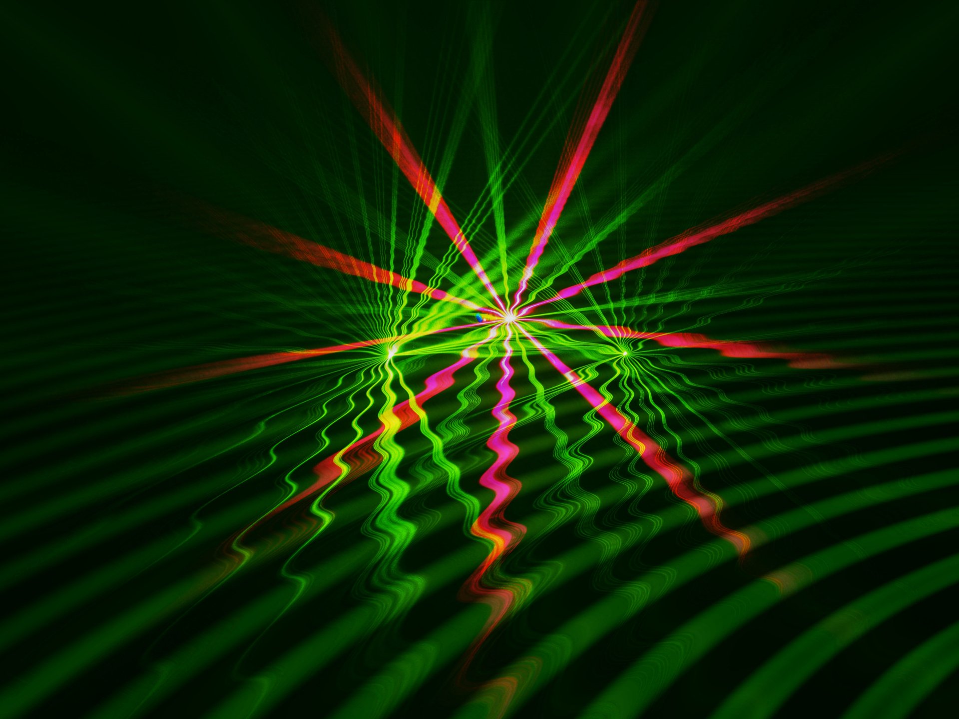 Colorful abstract green design with red and pink light beams over wavy patterns, rendered in vibrant 4K Ultra HD detail for a dynamic PC desktop wallpaper.
