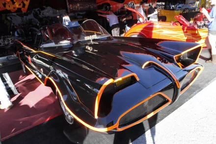 A striking image of the iconic Batmobile, showcasing its sleek black design and vibrant orange accents, serves as a captivating HD PC desktop wallpaper and background.