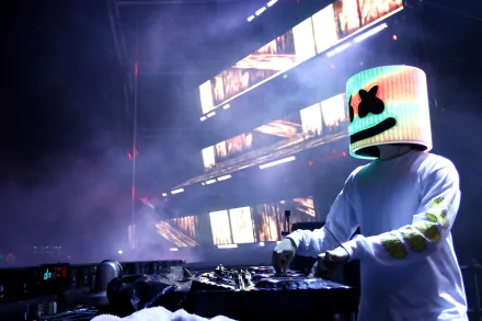 5K Ultra HD PC desktop wallpaper of an American electronic music DJ wearing a glowing marshmallow-shaped helmet, performing a live set with colorful LED screens and stage haze.