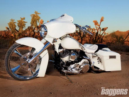 White Harley-Davidson Street Glide motorcycle with chrome accents and oversized front wheel parked in a desert at sunset — HD PC desktop wallpaper background.