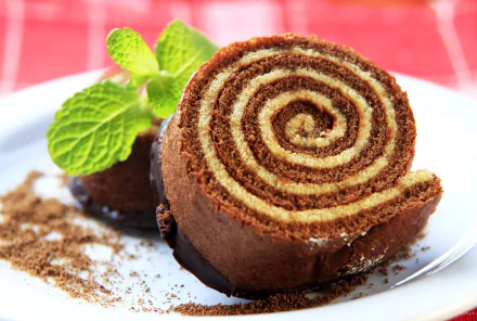 HD PC desktop wallpaper: close-up of a chocolate-rolled pastry dessert on a white plate, cocoa dusting and mint garnish — food pastry background