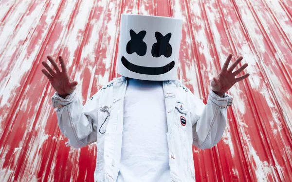 DJ Marshmello poses with hands raised against a vibrant red background, captured in a striking 4K Ultra HD music-themed desktop wallpaper.