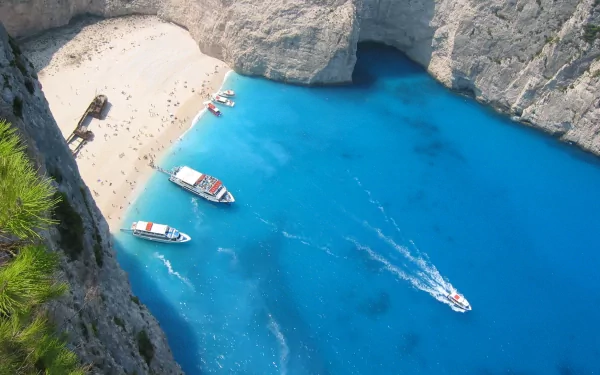 HD PC desktop wallpaper featuring a stunning nature scene with turquoise waters, boats, and a sandy beach surrounded by towering cliffs.
