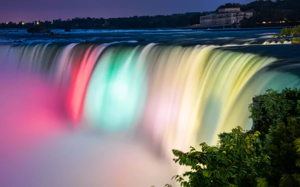 Niagara Falls waterfall illuminated with vibrant colors at night, captured in stunning 8K Ultra HD for a striking nature desktop wallpaper background.