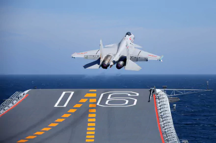 A Shenyang J-15 warplane, a military jet fighter, takes off from the deck of an aircraft carrier over the ocean in this 4K Ultra HD desktop wallpaper.