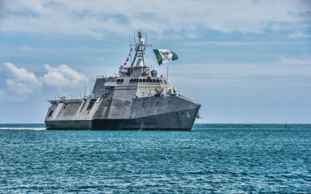 4K Ultra HD image of the USS Coronado (LCS-4), a United States Navy coastal defense warship, cruising on calm blue waters under a partly cloudy sky.