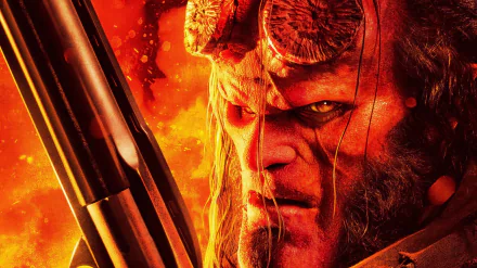Close-up HD PC desktop wallpaper of Hellboy from the 2019 Hellboy movie, featuring his intense gaze and distinct stone-like horns against a fiery background.