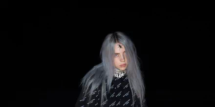 HD desktop wallpaper of Billie Eilish in a dark setting with striking grey hair and a patterned outfit.